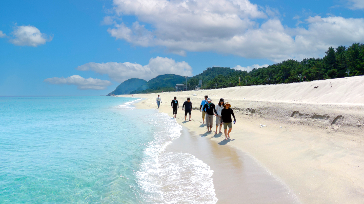 관광객들이 울진 구산해수욕장에서 맨발로 걷고 있다. 울진군 제공