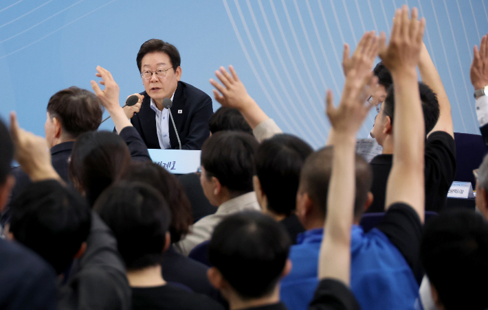 25일 부산 부경대에서 이재명 대통령이 참석한 가운데 열린 타운홀미팅 '부산의 마음을 듣다' 간담회에서 시민들이 손을 들어 발언권을 요청하고 있다. 연합뉴스