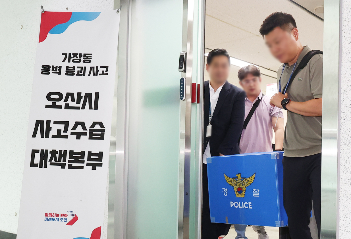지난 22일 경기 오산시 가장교차로 고가도로의 옹벽이 붕괴해 아래 도로를 지나던 차량 운전자 1명이 숨진 사고와 관련해 경찰이 오산시청 압수수색을 하는 모습. 연합뉴스