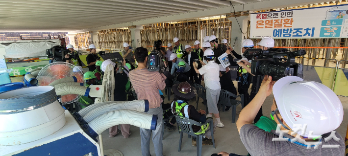 유 시장이 공사장 노동자들에게 시원한 음료를 건네며 애로사항을 청취하고 있다. 박창주 기자