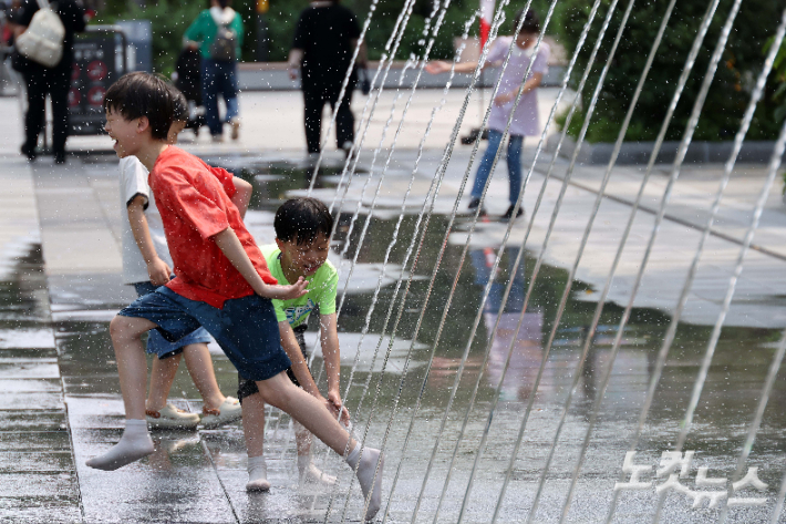 전국 대부분 지역에 폭염경보가 내려진 26일 서울 광화문광장 바닥분수에서 어린이가 더위를 피하고 있다. 박종민 기자