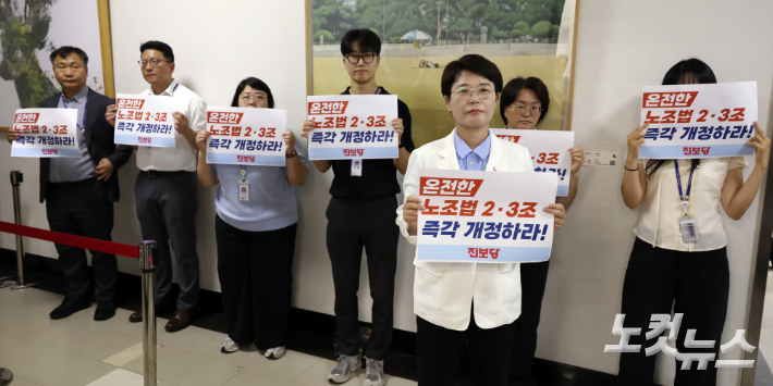 진보당 전종덕 의원과 당직자들이 28일 서울 여의도 국회에서 열린 환경노동위원회 고용노동법안심사소위 회의장 앞에서 노조법 2·3조 개정을 촉구하는 피켓을 들고 있다. 윤창원 기자