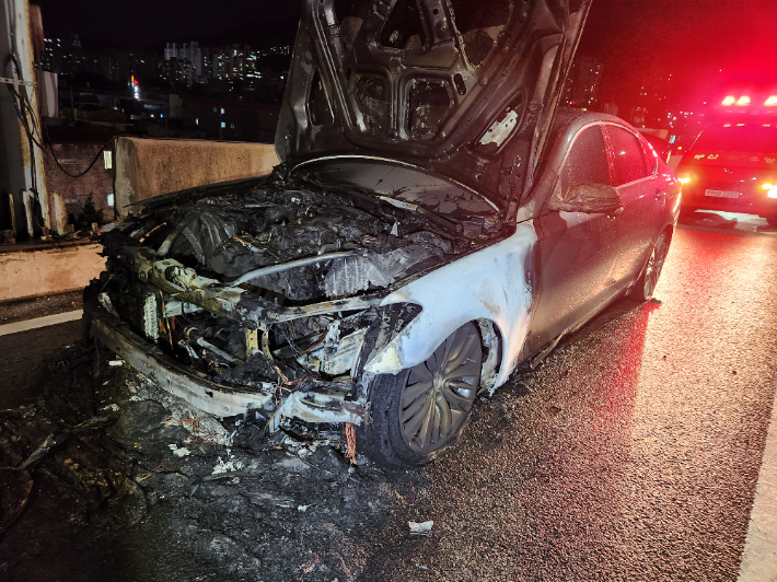 29일 오후 10시 25분쯤 부산 사상구 관문대로에서 앞선 사고로 쓰러진 가로등을 밟고 지나간 승용차에 불이 났다. 부산소방재난본부 제공