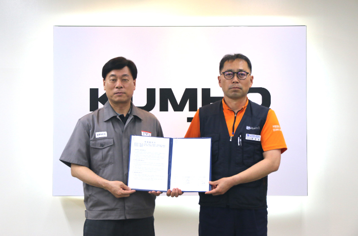 김명선 금호타이어 생산기술총괄 부사장(사진 왼쪽)과 황용필 금호타이어지회 대표 지회장이 노사 특별합의문을 들고 사진을 찍고 있다. 금호타이어 제공