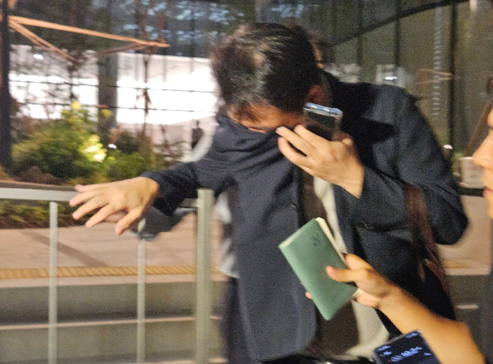 김건희 여사 오빠인 김진우 씨가 28일 김 여사 관련 의혹들을 수사하는 민중기 특별검사팀 사무실이 위치한 서울 종로구 KT광화문빌딩에서 조사를 마친 뒤 얼굴을 가린 채 특검 사무실을 나서고 있다. 연합뉴스