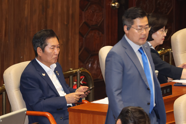 더불어민주당 정청래 당대표 후보가 지난달 23일 국회 본회의장에서 박찬대 당대표 후보를 바라보고 있다. 연합뉴스