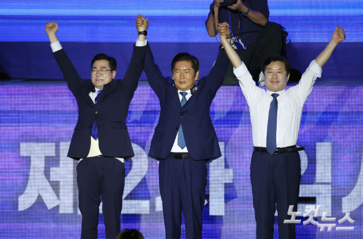 더불어민주당 정청래 신임 당대표(가운데)가 박찬대 후보, 황명선 신임 최고위원과 2일 오후 2일 오후 경기 고양시 킨텍스에서 열린 제2차 임시전국당원대회에서 손을 들어보이고 있다. 황진환 기자