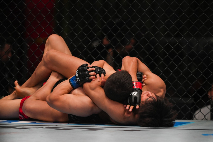 타이라(사진 오른쪽)의 리어네이키드 초크에 걸려든 박현성. UFC 제공