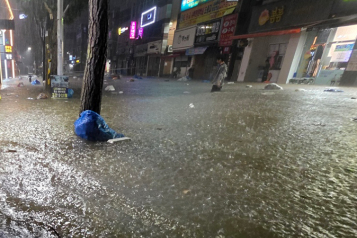무안군을 중심으로 광주·전남 곳곳에 극한호우가 쏟아진 3일 오후 광주 북구 운암동 도심에서 한 시민이 침수된 거리를 이동하고 있다. 독자 제공