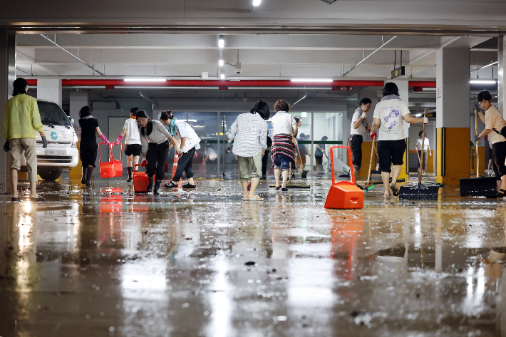 호우 특보가 발효돼 시간당 142.1㎜의 집중 호우가 쏟아진 4일 오전 전남 무안군 군 보건소 지하 주차장이 빗물에 잠겨 직원들이 배수 작업을 하고 있다. 연합뉴스