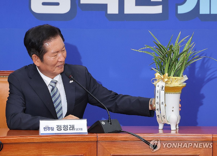 (서울=연합뉴스) 류영석 기자 = 더불어민주당 정청래 신임 대표가 4일 국회 당대표실에서 우상호 대통령실 정무수석으로부터 받은 이재명 대통령의 취임 축하 난을 보고 있다. 2025.8.4 ondol@yna.co.kr 연합뉴스