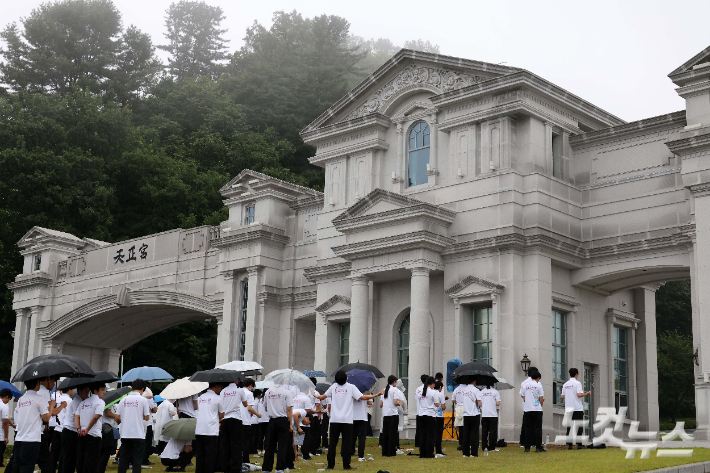 지난달 18일 오전 김건희 여사 관련 의혹을 수사하는 민중기 특별검사팀이 이른바 '건진법사 게이트'와 관련해 통일교 압수수색에 착수했다. 건진법사 게이트는 무속인 건진법사 전성배 씨가 2022년 교단 현안 관련 청탁을 받고 통일교 측으로부터 김건희 여사 선물용으로 받은 샤넬 백과 고가의 목걸이 등을 김 여사에게 전달했다는 의혹이다. 검찰이 압수수색에 나선 통일교 천정궁은 한학자 총재의 거주지로도 알려져 있다. 사진은 이날 가평 천정궁 앞에 모인 신도들의 모습. 가평=박종민 기자