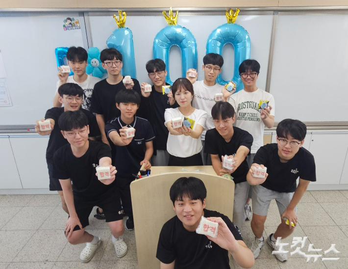 청주 운호고등학교 학생들이 '합격' 글자가 쓰인 떡을 들고 기념 촬영을 하고 있다. 임성민 기자