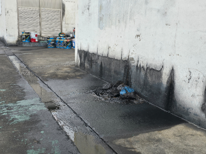 폐유보관시설 외부로 흐른 폐유들과 이를 덮은 천이 뒤엉켜 굳었다. 이창준 기자 