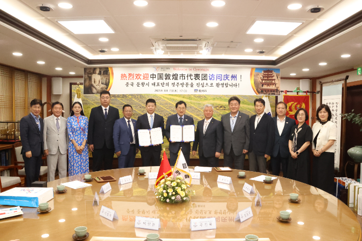 경주시와 둔황시 대표단이 우호협력 협정 체결 후 단체 기념사진을 촬영하고 있다. 앞줄 왼쪽 여섯 번째부터 왕얜췬 둔황시 당서기와 주낙영 경주시장. 경주시 제공