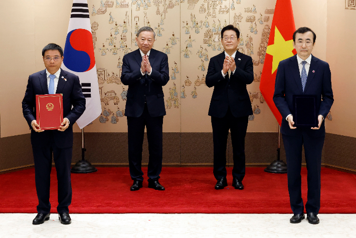 이세훈 금융감독원장 대행과 응우옌 반 탕 베트남 재무부 장관이 11일 서울 용산 대통령실 청사에서 이재명 대통령과 또 럼 베트남 당 서기장이 임석한 가운데 열린 양해각서(MOU) 서명식에서 금융감독당국 간 협력 MOU에 서명 뒤 기념촬영을 하고 있다. 연합뉴스