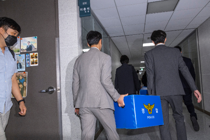 서울경찰청 금융범죄수사대 전담수사팀 관계자들이 11일 주식 차명거래 혐의를 받는 이춘석 의원의 국회 사무실 압수수색을 마친 뒤 압수품을 들고 의원실을 나서고 있다. 연합뉴스