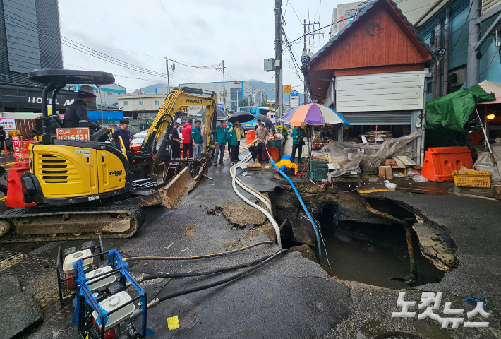 12일 부산 사상구 감전동 새벽시장 입구에 발생한 싱크홀 내부 배수 작업이 진행되고 있다. 김혜민 기자 