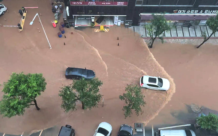 수도권에 많은 비가 내린 13일 경기도 고양시 화중로 화정역 인근 침수된 골목에서 차량이 서행하고 있다. 연합뉴스