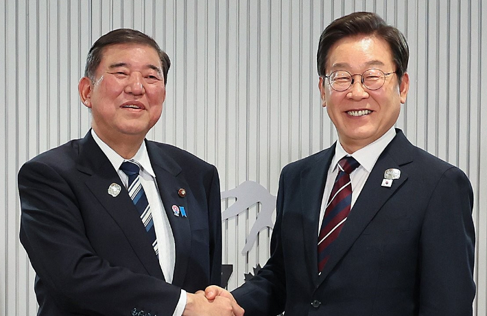 이재명 대통령(오른쪽)이 이시바 시게루 일본 총리와 악수하며 기념촬영을 하고 있다. 연합뉴스