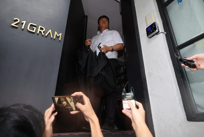 김건희 여사의 각종 의혹을 수사하는 민중기 특별검사팀 수사관이 서울 성동구에 위치한 인테리어 업체 '21그램'에 13일 압수수색을 위해 건물로 들어가고 있다. 연합뉴스