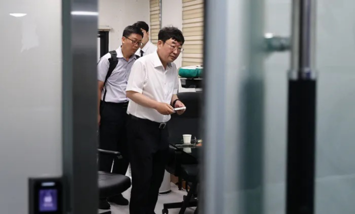 유튜브 채널 '신의한수' 운영자 신혜식 대표가 13일 서울 마포구 사무실에서 윤석열 정부 시절 대통령실의 민간인 시위대 동원 의혹과 관련해 서울경찰청 안보수사과 수사관들에게 휴대전화를 임의제출 하고 있다. 연합뉴스