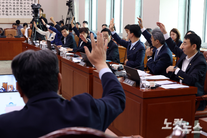 지난 1일 서울 여의도 국회에서 열린 법제사법위원회에서 이춘석 위원장과 더불어민주당 의원들이 거수 표결을 하고 있다. 이날 법사위는 윤석열 정부 당시 재의요구권(거부권) 행사로 불발된 방송3법(방송법·방송문화진흥회법·한국교육방송공사법)과 노란봉투법(노동조합 및 노동관계조정법 2·3조 개정안)을 여당(더불어민주당) 주도로 의결했다. 윤창원 기자