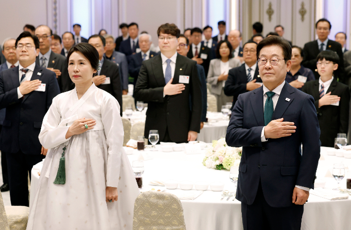 이재명 대통령과 김혜경 여사가 14일 청와대 영빈관에서 열린 '광복 80주년, 대통령의 초대' 행사에서 참석자들과 국기에 경례하고 있다. 연합뉴스