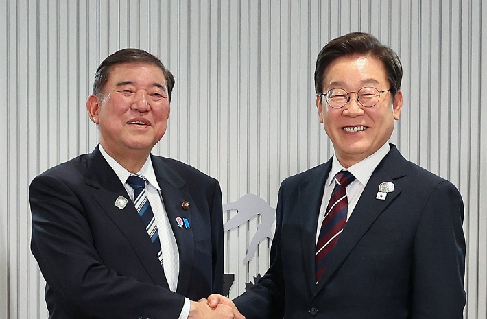 이재명 대통령(오른쪽)과 이시바 시게루 일본 총리가 악수하며 기념촬영을 하고 있다. 연합뉴스