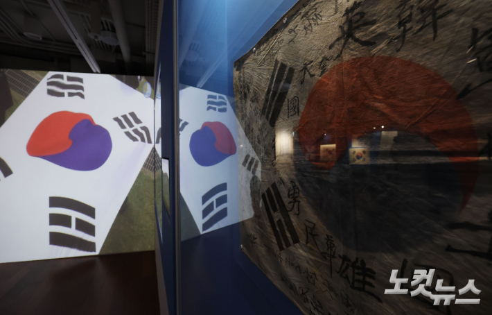 제80주년 광복절을 하루 앞둔 14일 서울 종로구 대한민국역사박물관에서 시민들이 '광복 80주년 기념 특별전-태극기 함께 해온 나날들'을 관람하고 있다. 류영주 기자