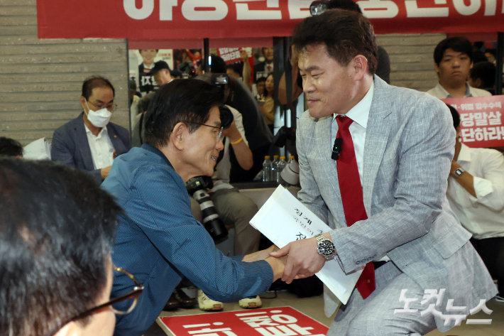 전한길 전 한국사 강사가 14일 오전 서울 여의도 국민의힘 중앙당사에서 열린 중앙윤리위원회 회의에 출석하며 전날 특검의 국민의힘 당사 압수수색을 규탄하며 농성중인 김문수 당대표 후보와 인사를 하고 있다. 윤창원 기자