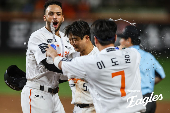 한화 이원석(가운데)이 14일 롯데와 홈 경기에서 연장 11회말 끝내기 밀어내기 볼넷을 얻어낸 뒤 동료들의 격한 축하를 받고 있다. 한화 이글스