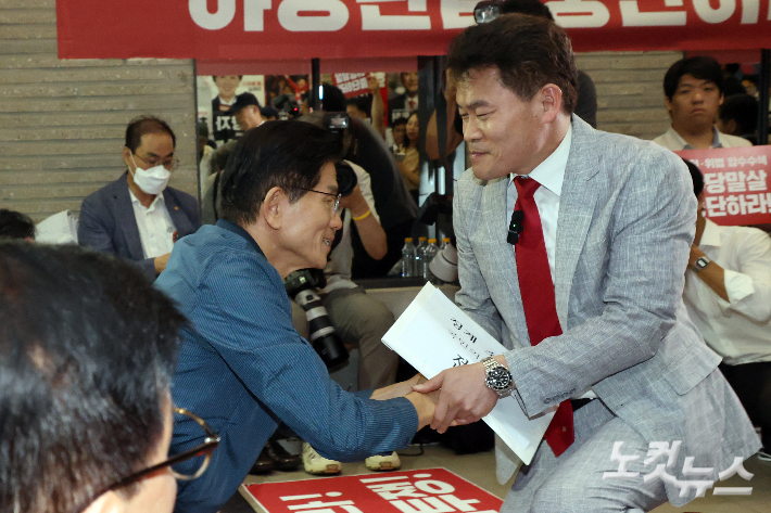 전한길 전 한국사 강사가 14일 오전 서울 여의도 국민의힘 중앙당사에서 열린 중앙윤리위원회 회의에 출석하며 전날 특검의 국민의힘 당사 압수수색을 규탄하며 농성중인 김문수 당대표 후보와 인사를 하고 있다. 윤창원 기자