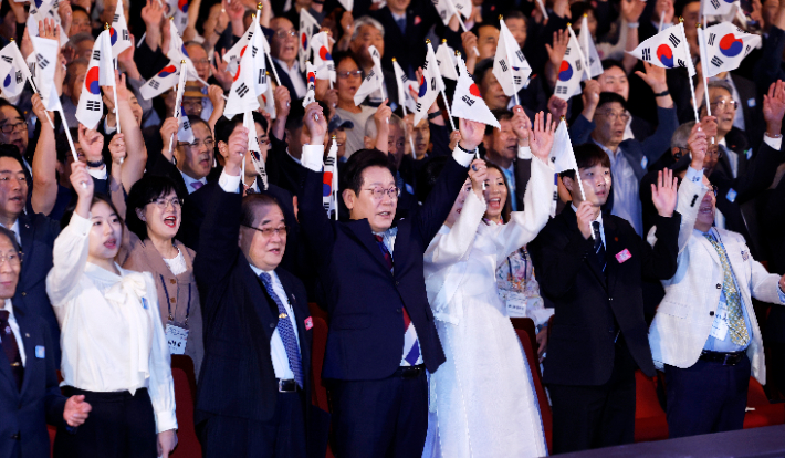 이재명 대통령과 김혜경 여사가 15일 서울 세종문화회관에서 열린 80주년 광복절 경축식에서 참석자들과 만세 삼창을 하고 있다. 연합뉴스
