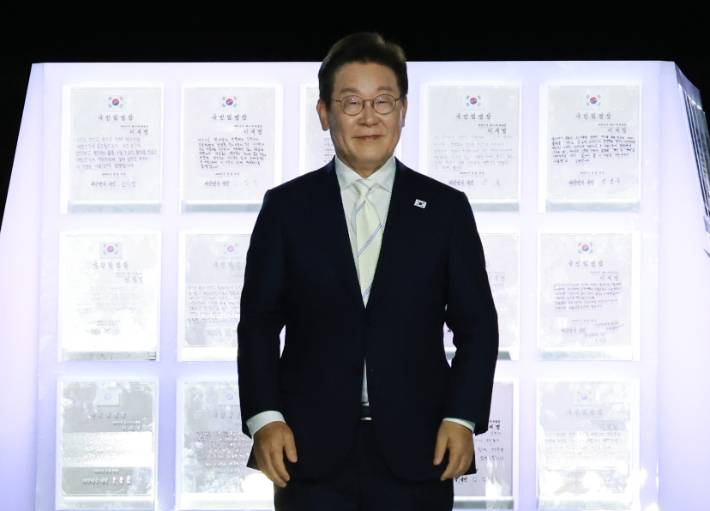 이재명 대통령이 15일 서울 세종대로 광화문광장에서 열린 제21대 대통령 국민임명식 '광복 80년, 국민주권으로 미래를 세우다' 행사에서 국민대표가 전달한 '빛의 임명장'과 함께 자리하고 있다. 연합뉴스