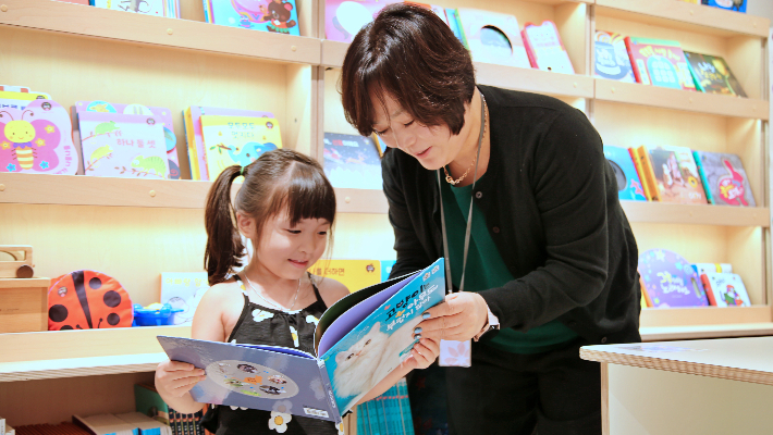 한 직원이 광주신세계 본관 6층 아람북스 매장에서 어린이 고객에게 도서를 소개하고 있다. 광주신세계 제공