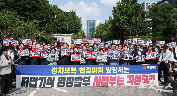 송언석 국민의힘 비상대책위원장 겸 원내대표 등 의원들이 18일 오후 서울 서초구 서울중앙지방법원 앞에서 현장 비상의원총회을 열고 '야당탄압 정치보복 압수수색 규탄' 구호를 외치고 있다. 류영주 기자