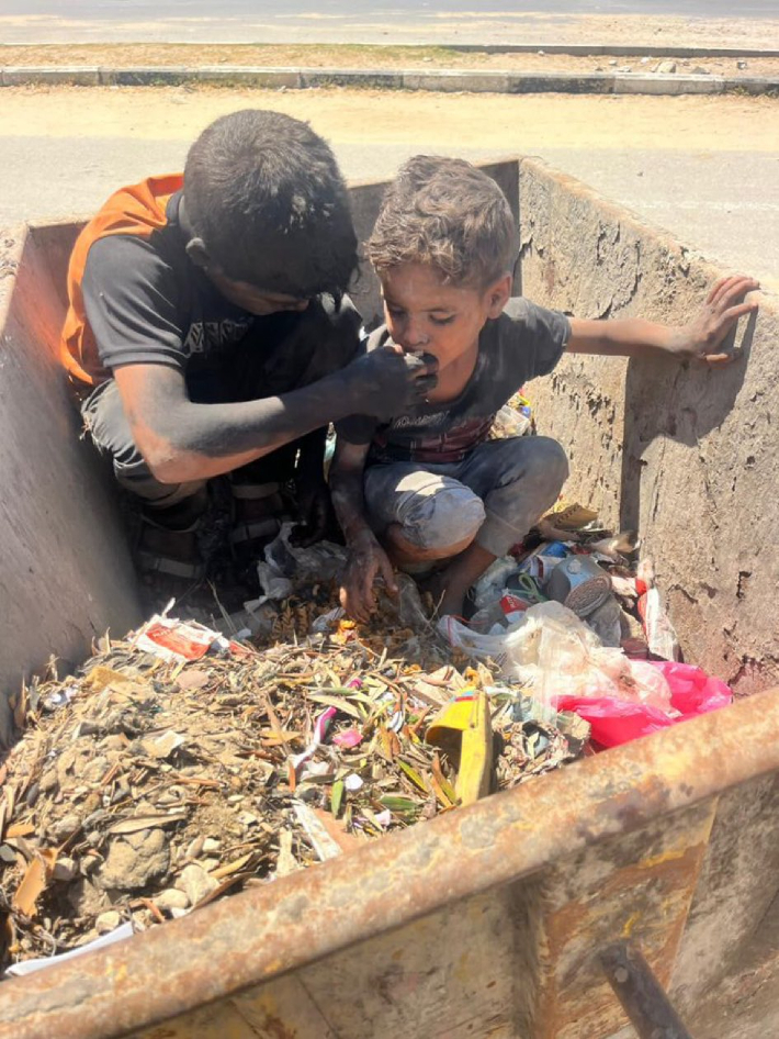 수레 위 쓰레기 더미에 앉은 어린 형제가 음식을 주워 먹고 있다. 굶주림에 내몰린 아이들의 절박한 삶을 보여주는 현장이다. X 캡처