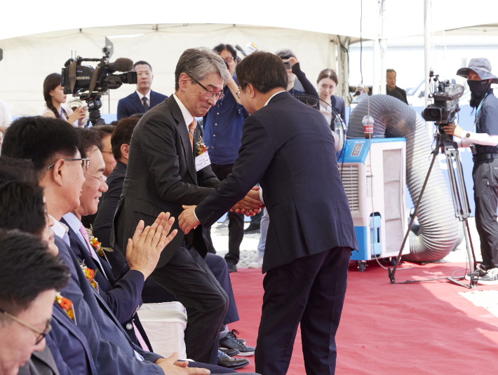 김동연 경기지사(오른쪽)가 20일 경기경제자유구역청 평택 포승(BIX)지구 산업단지에서 열린 'TOK첨단재료㈜ 평택 공장 착공식'에서 축사를 한 뒤 연단에 내려와 일본 TOK(도쿄오카공업) 타네이치 노리아키 대표와 악수하는 모습. 경기도 제공