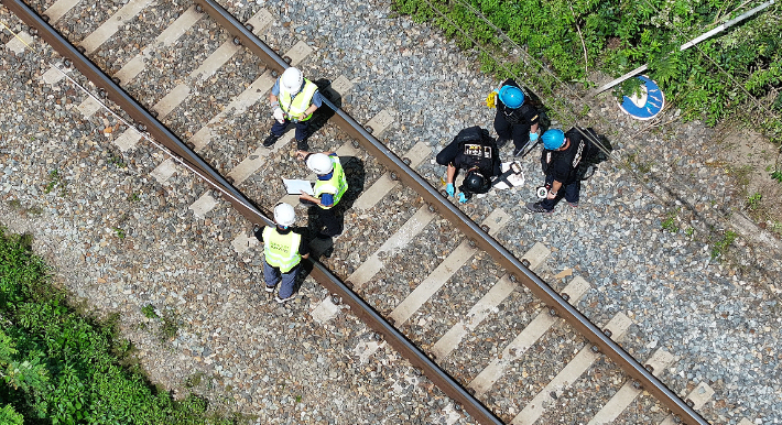 20일 경북 청도군 화양읍 삼신리 청도소싸움 경기장 인근 경부선 철로에서 전날 발생한 열차 사고에 대한 유관기관 합동 감식이 진행 중인 가운데 항공철도사고조사위원회 관계자가 침목에 '사고 지점'이라고 적힌 장소를 조사하고 있다. 연합뉴스