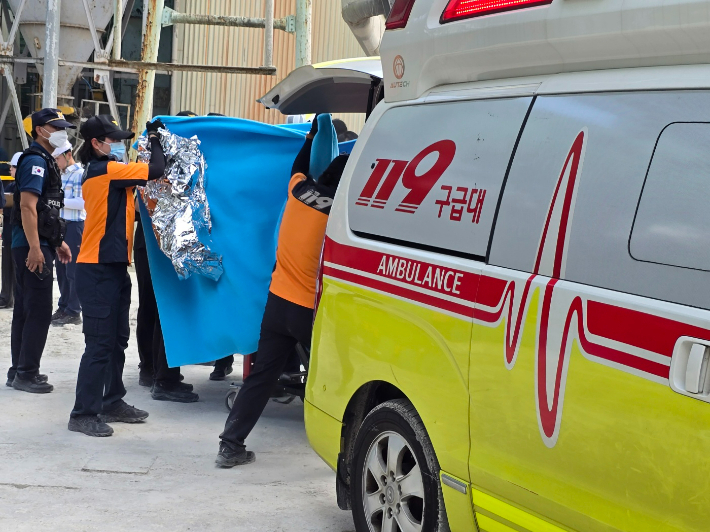 레미콘공장 사고 현장에서 요구조자를 담요로 가린 채 구급차에 옮기고 있다. 고영호 기자
