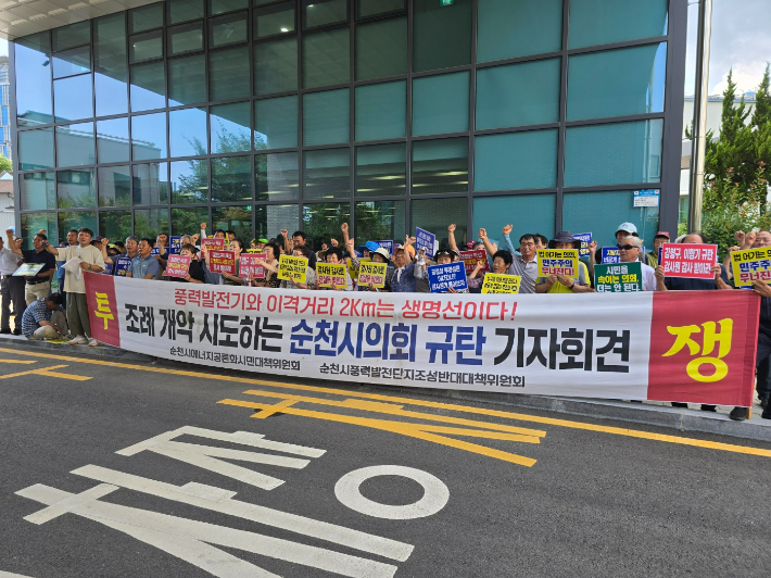 풍력반대위가 공청회장 앞에서 '이격거리 조례 개악' 규탄 기자회견을 하며 구호를 외치고 있다. 고영호 기자 