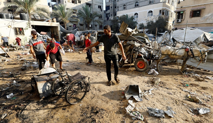 22일(현지시간) 가자지구 북부 가자시티에서 주민들이 폭격 피해 지역을 살피고 있다. 연합뉴스