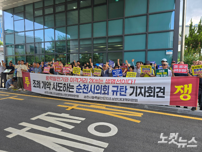 풍력반대위가 공청회장 앞에서 '이격거리 조례 개악' 규탄 기자회견을 하며 구호를 외치고 있다. 고영호 기자 