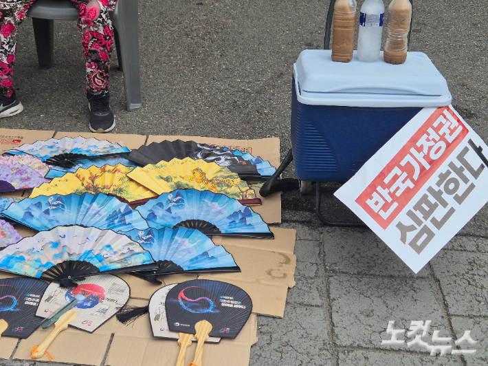 자유통일당 등은 23일 서울 광화문광장에서 '8·23 광화문 혁명 국민대회'를 진행했다. 서울 한낮 기온이 34도까지 치솟은 탓에 집회 현장에서 부채가 판매되는 모습. 주보배 기자 