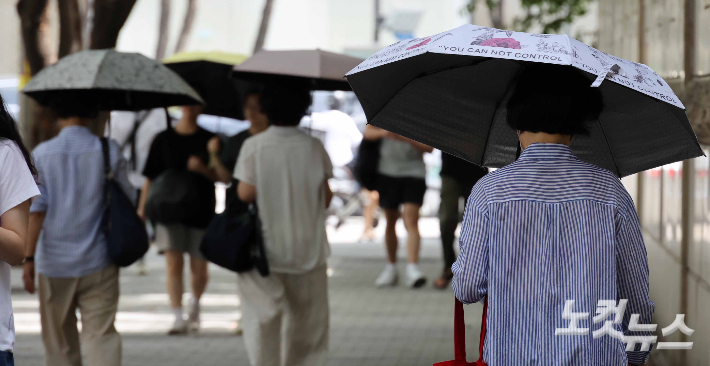 폭염에 남녀 구분없이 양산을 쓰고 다니는 시민들. 박종민 기자