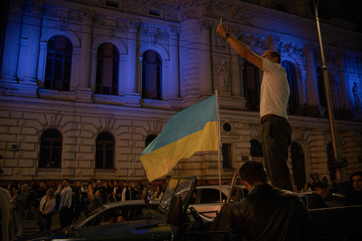24일(현지시간) 하르키우 중심부에서 열린 우크라이나 독립기념일 기념행사에서 한 남성이 우크라이나 국기 옆에 서서 사진을 찍고 있다. 연합뉴스
