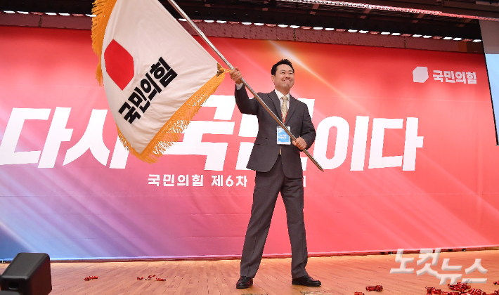 국민의힘 장동혁 신임 당대표가 26일 오전 서울 여의도 국회 도서관에서 열린 제6차 전당대회 결선에서 당기를 흔들고 있다. 황진환 기자