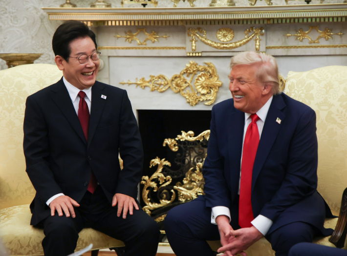 이재명 대통령이 25일(현지시간) 미국 워싱턴 DC 백악관 오벌오피스에서 도널드 트럼프 미국 대통령과 한미 정상회담을 하며 함께 웃고 있다. 연합뉴스