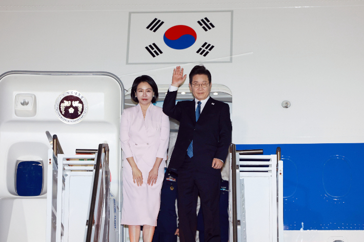 이재명 대통령과 김혜경 여사가 26일(현지시간) 미국 펜실베이니아주 필라델피아국제공항에서 미국 방문 일정을 마친 뒤 귀국하며 공군 1호기에 올라 인사하고 있다. 연합뉴스